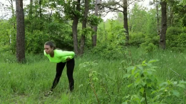 Hermosa joven haciendo ejercicio en el día de verano parque — Vídeo de stock