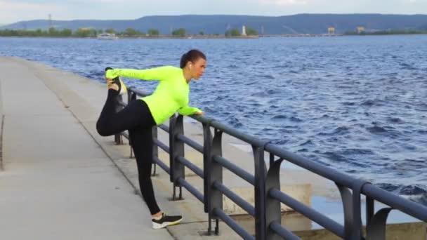 Sportovní žena cvičení a strečink na pozadí hory nábřeží města — Stock video