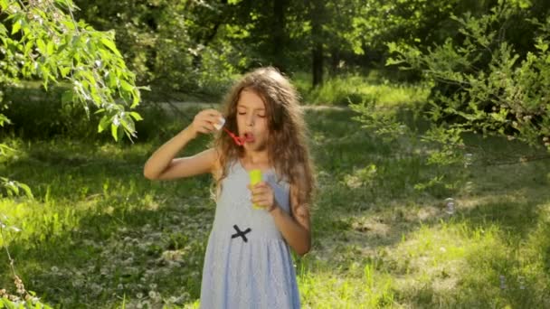 Šťastné malé děvče hraje důvtip mýdlové bubliny venkovní, rajský a usmívá se — Stock video