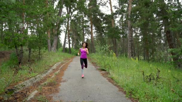 Junges attraktives Mädchen, das in Zeitlupe durch den Wald rennt — Stockvideo