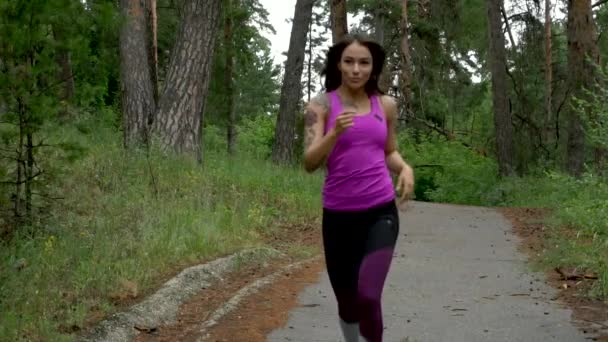 Fitness training buitenshuis. Sport vrouw loopt door het bos. Slow motion. — Stockvideo