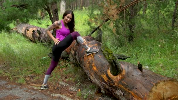 Sportieve meisje in een park in de buurt van het bos. Uitvoeren die zich uitstrekt. Slow motion. — Stockvideo
