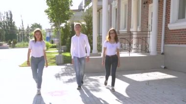 Üç kız ve erkek benzer kot pantolon ve gömlek sokakta dans giymiş