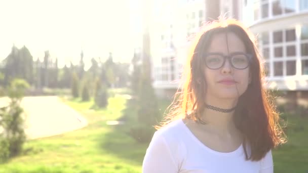 Відео-портрет дівчини-підлітка в окулярах дивитися на камеру посмішки показують брекети — стокове відео