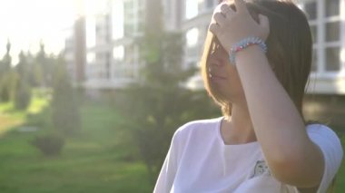 Video portre genç güzel genç kız şehir sokakta yürürken gülümseyen