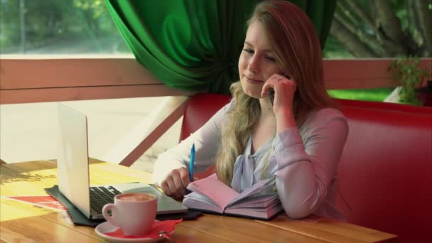 Γυναίκα των επιχειρήσεων σε μια καφετέρια που λειτουργεί και μιλάμε για το έξυπνο τηλέφωνο — Αρχείο Βίντεο