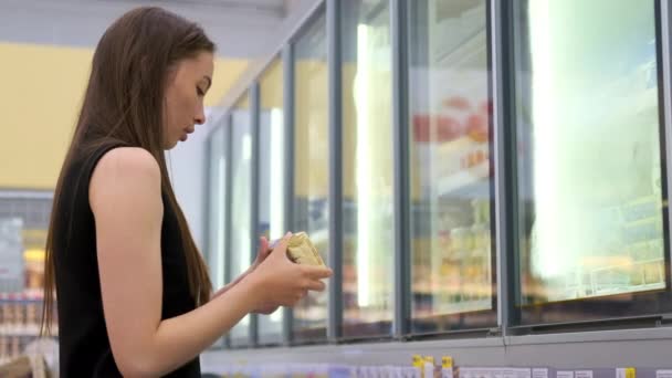 Jovem mulher comprando produtos semi-acabados congelados na loja — Vídeo de Stock