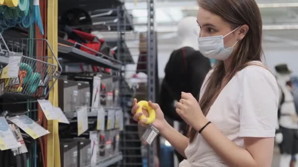 TOLYATTI, RUSSIA - 10 LUGLIO 2020: shopping alla pandemia di COVID-19, donna con maschera facciale in negozio sportivo — Video Stock