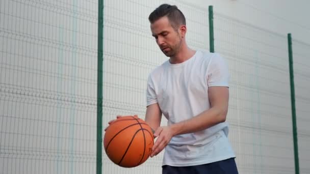 Giovane maschio sta giocando a basket al di fuori — Video Stock