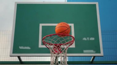 Tanınmayan insan basketbol oynuyor, topa potaya vuruyor.