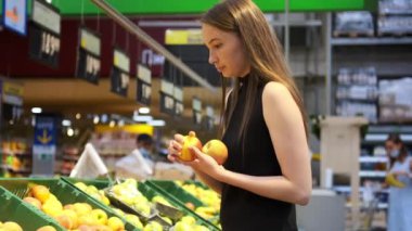 Meyve ve sebze reyonundan elma alan genç bir kadın