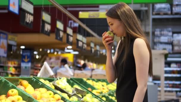 Vrouw kiest appels in fruit afdeling in supermarkt — Stockvideo