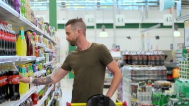Genç adam marketten gazoz alıyor.