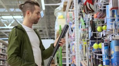 TOLYATTI, RUSSIA - 15 Temmuz 2020: Beyzbol oyuncusu spor malzemeleri mağazasından bir yarasa seçiyor