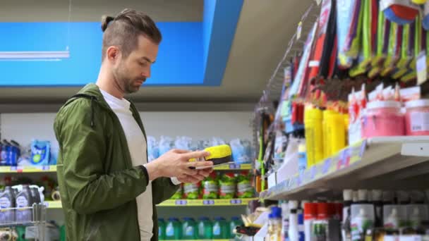 Pria muda membeli mobil spons di toko khusus — Stok Video