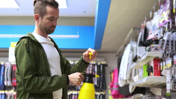 Anak muda membeli botol semprotan di toko khusus — Stok Video