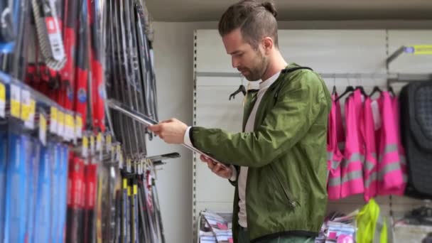 Ο νεαρός αγοράζει υαλοκαθαριστήρες σε ειδικό κατάστημα. — Αρχείο Βίντεο