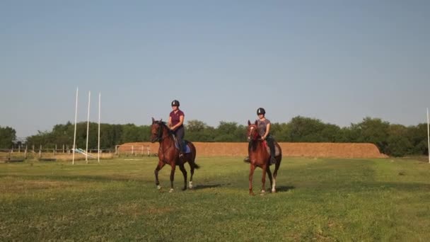 Two females equestrians riding horses at country racetrack — Stock Video