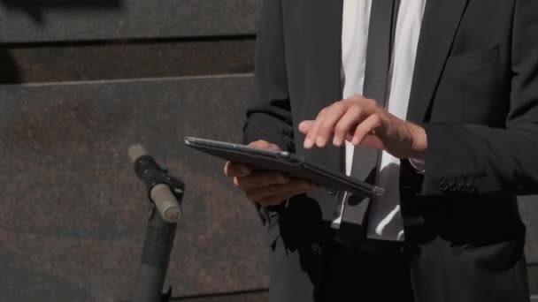 Drukke zakenman het controleren van bestanden op tablet computer outdoor — Stockvideo