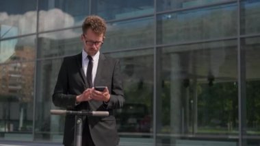 Adam iş bölgesindeki akıllı telefondan mesaj yazıyor.