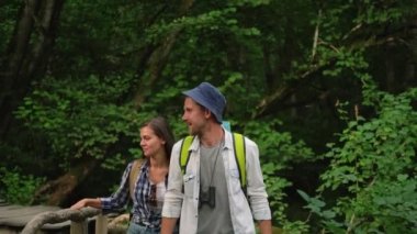 Bir çift turist ormanda yürüyor, doğal işaretleri görüyorlar.