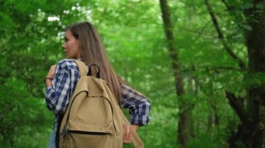 Sırt çantalı genç bayan ormanda tek başına seyahat ediyor.
