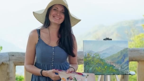 Happy woman artist and her picture with landscape — Stock Video