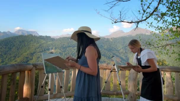 Dos mujeres maestras pintando paisaje de montaña al aire libre — Vídeos de Stock