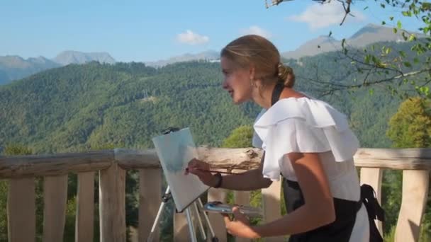 Professional painter, woman is drawing a picture of mountainscape — Vídeos de Stock