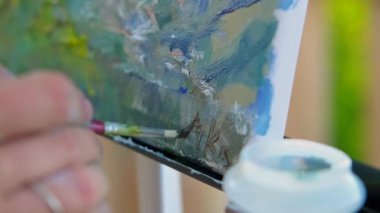 artist is signing new picture, autograph on canvas