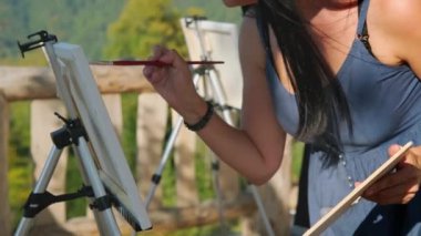 Kadın plein air 'da resim çiziyor.