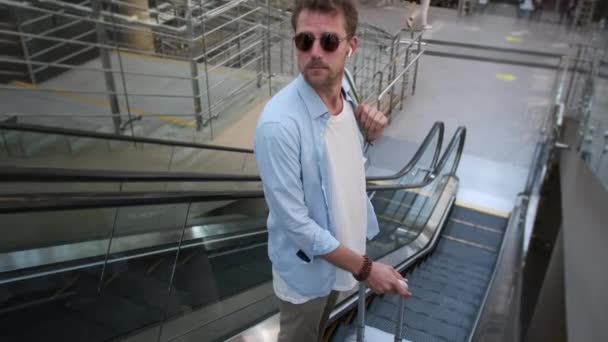 Homem está se movendo para baixo na escada rolante no aeroporto — Vídeo de Stock