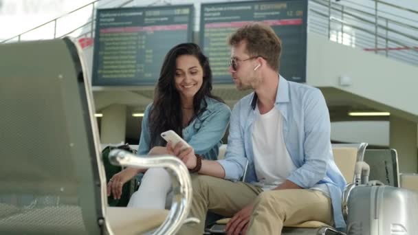 Feliz hombre y mujer esperando el viaje en tren en la estación — Vídeos de Stock