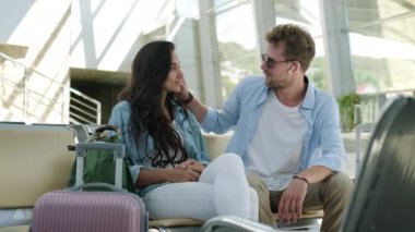 Birkaç yolcu havaalanı terminalinde bekliyor.