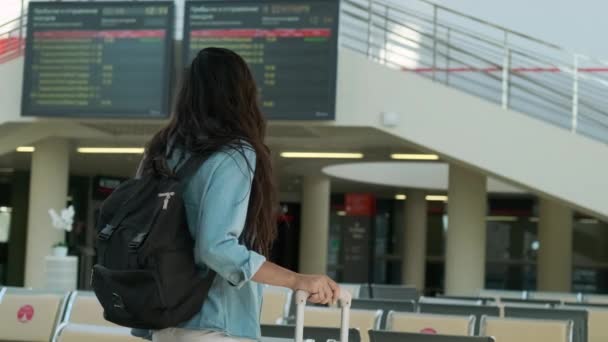 Ung kvinna står i lobbyn på järnvägsstationen med bagage — Stockvideo
