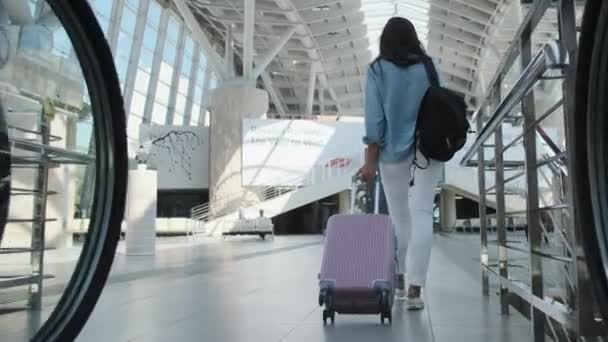 Büyük modern tren terminalindeki yolcular, kadın valizi yuvarlıyor. — Stok video