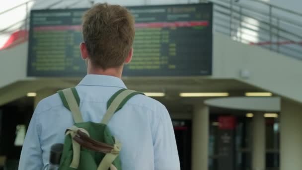 Reisender überprüft Abflug- und Ankunftsplan am Flughafen — Stockvideo