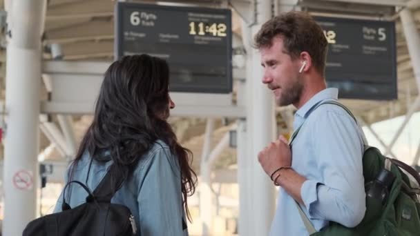 Hombre y mujer en la estación de tren, tren de espera — Vídeos de Stock