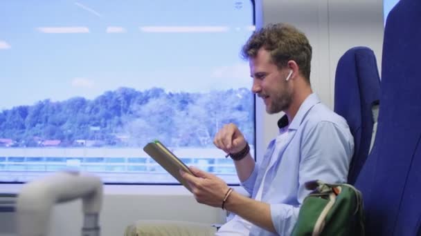 Happy man holding tablet en het hebben van video chat in de trein — Stockvideo