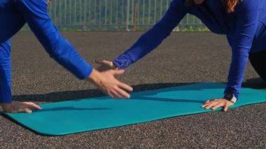 Evli çift şınav çekiyor ve el çırpıyor.