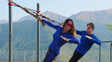 Uzaklaştırma egzersizi. Erkek ve kadın dışarıda tuzak kayışları kullanıyor.