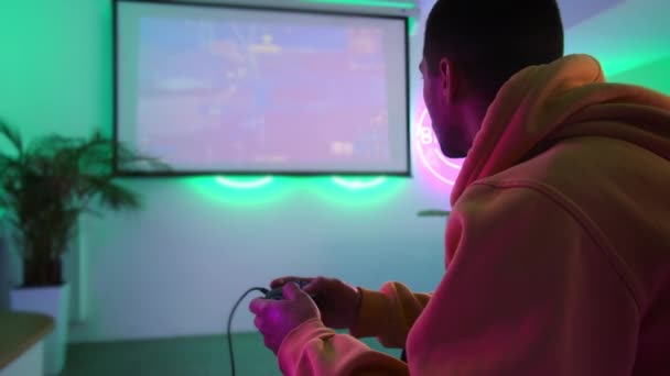 Διασκέδαση κλαμπ με βιντεοπαιχνίδια, νεαρός άνδρας παίζει παιχνίδι shooter — Αρχείο Βίντεο