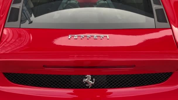 Червоний Феррарі з логотипом жеребця позаду. — стокове відео