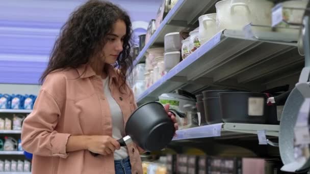 Cliente feminino escolhendo uma panela no hipermercado — Vídeo de Stock