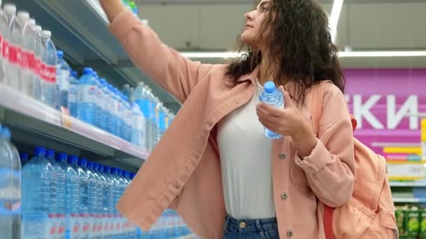 Mujer está comprando agua embotellada en el supermercado — Vídeo de stock