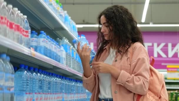 Donna che compra acqua minerale al supermercato — Video Stock