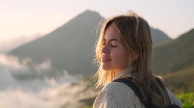 Sırt çantalı kız dağ manzarasına bakıyor.