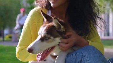 Kız, köpeğini sevgiyle okşuyor.