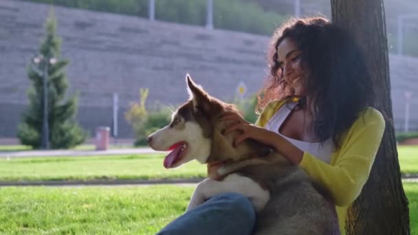 Meisje brengt heerlijke zomerdag met hond buiten — Stockvideo