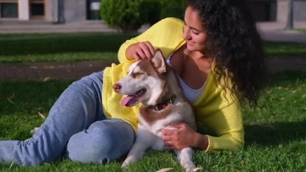 Meisje besteedt zorgeloos tijd met een hond buiten — Stockvideo